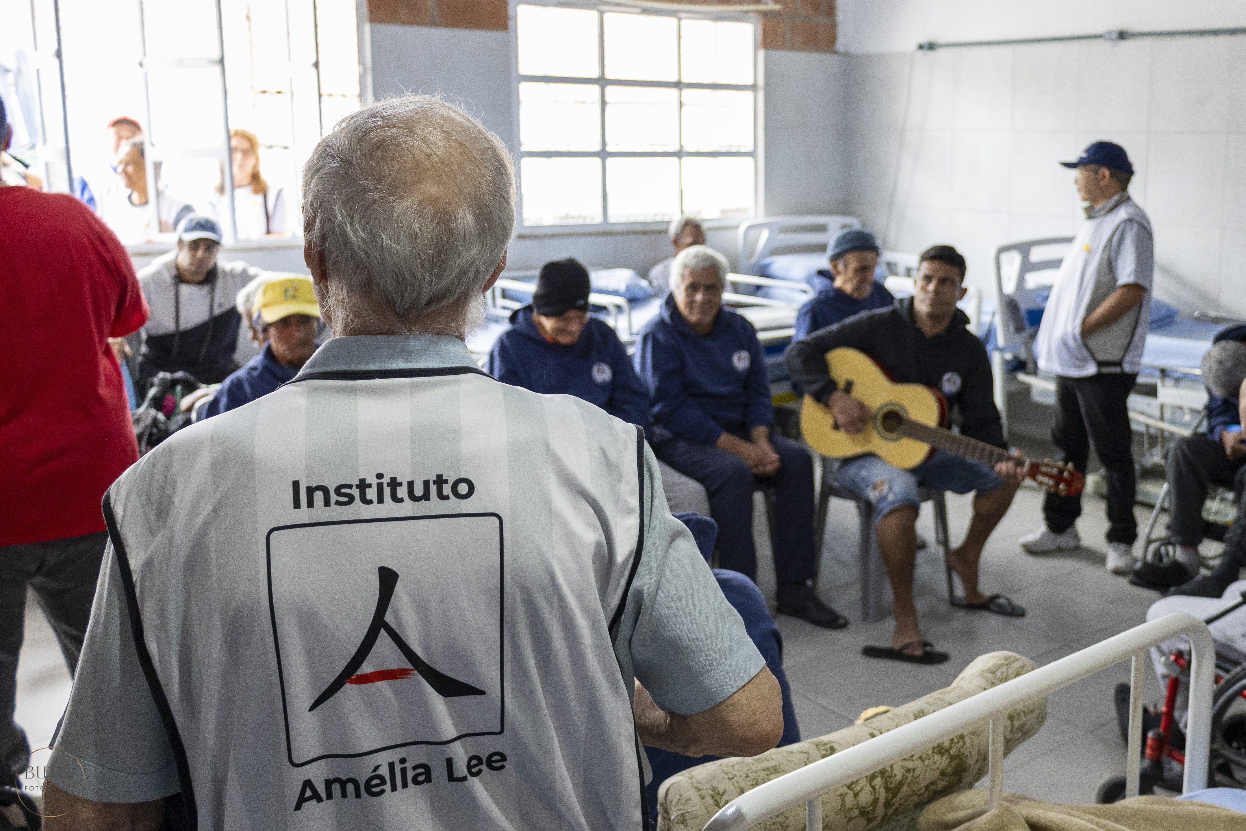 Voluntário com o colete do Instituto Amélia Lee em visita a idosos